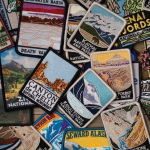 Custom embroidered patches featuring various national park designs, showcasing scenic landscapes and park names, relevant to Embellishway's custom embroidery offerings.