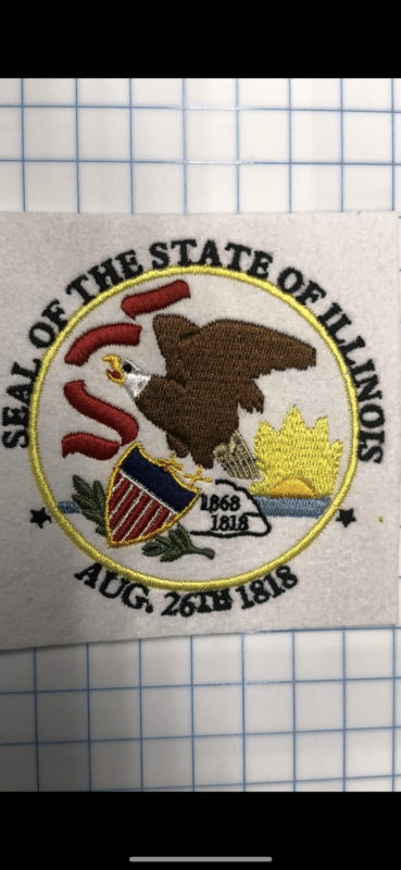 Seal of the State of Illinois featuring an eagle, shield, and the dates 1818 and 1868, surrounded by the text "SEAL OF THE STATE OF ILLINOIS" and "AUG. 26TH 1818."