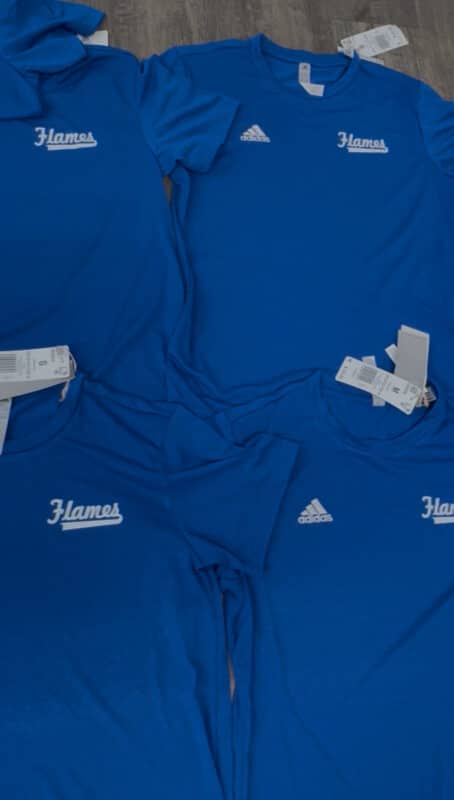 Blue athletic shirts with "Flames" logo and Adidas branding, stacked together, showcasing a collection of sports apparel.